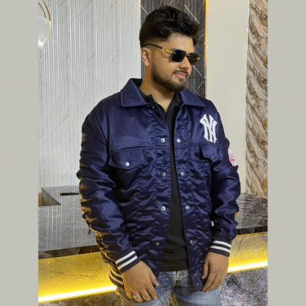 Men’s New York Yankees navy varsity satin jacket with snap buttons, rib-knit trim, and embroidered logos for a bold, retro team look.