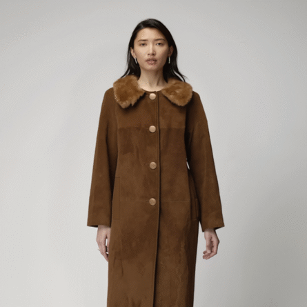 Women’s 70s-inspired long brown suede coat featuring a wide faux fur collar, large buttons, and a relaxed vintage silhouette for fall and winter style.