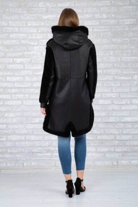 Women's black long trench coat featuring faux shearling material, faux fur-lined hood and cuffs, full front zipper closure, and warm, stylish winter design.